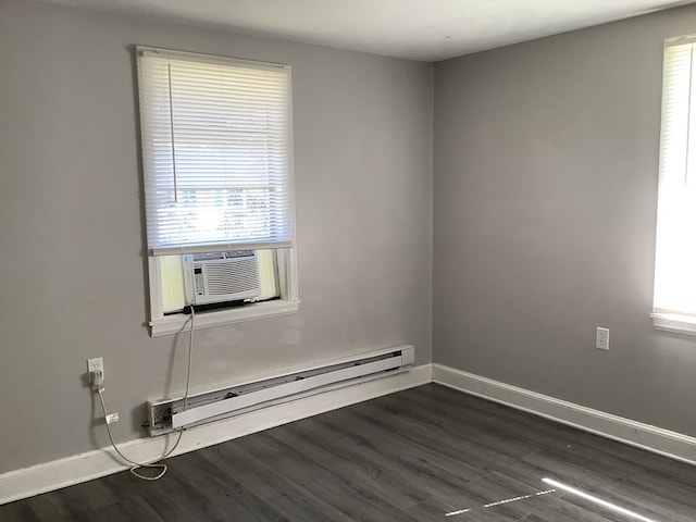 spare room with a baseboard heating unit, dark wood-type flooring, and baseboards