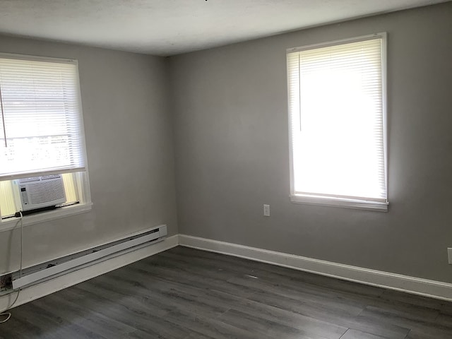 spare room featuring baseboard heating, cooling unit, dark wood finished floors, and baseboards