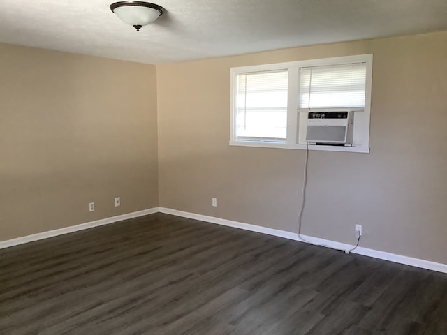 empty room featuring dark wood-type flooring and baseboards