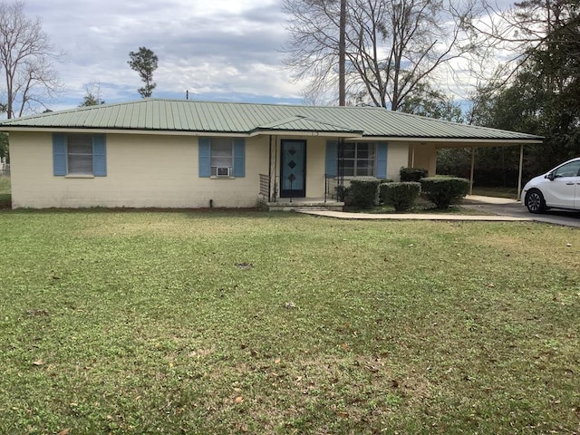 ranch-style house with concrete block siding, metal roof, an attached carport, cooling unit, and a front yard