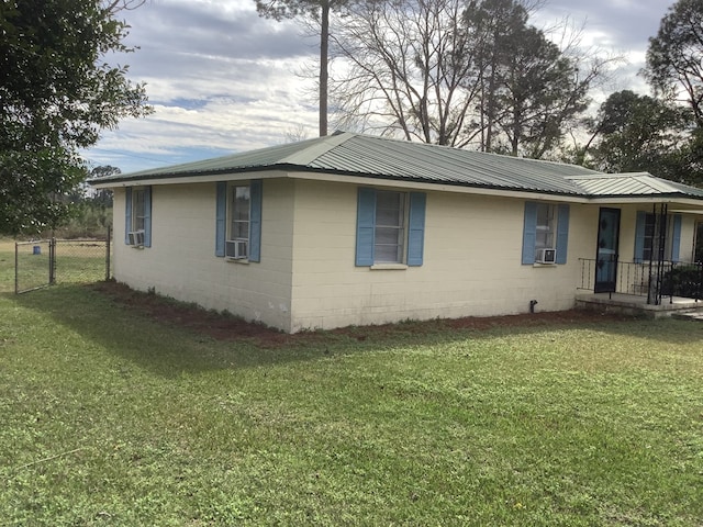 view of home's exterior featuring concrete block siding and a yard