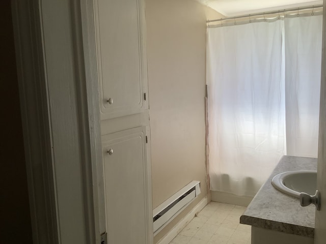 bathroom featuring curtained shower, a washtub, a baseboard heating unit, vanity, and tile patterned floors