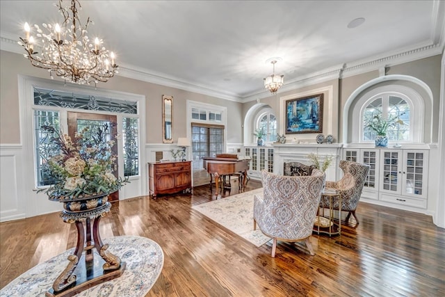 sitting room featuring hardwood / wood-style floors, an inviting chandelier, and ornamental molding