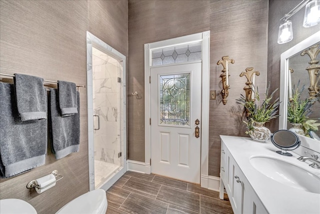 bathroom featuring toilet, an enclosed shower, and vanity