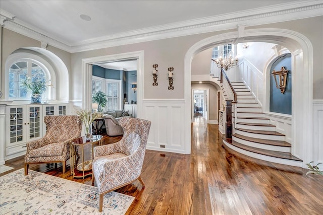 sitting room featuring dark wood-type flooring, ornamental molding, and an inviting chandelier