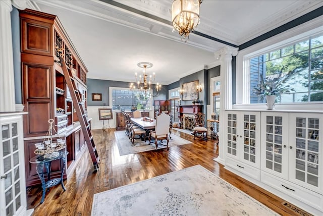 dining room featuring a healthy amount of sunlight, crown molding, and an inviting chandelier