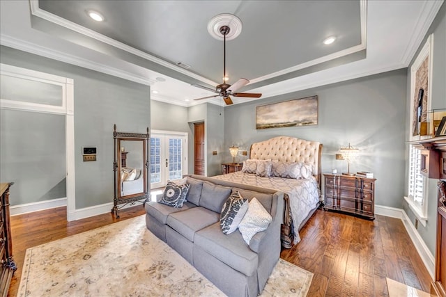 bedroom with french doors, dark hardwood / wood-style floors, ornamental molding, a raised ceiling, and ceiling fan