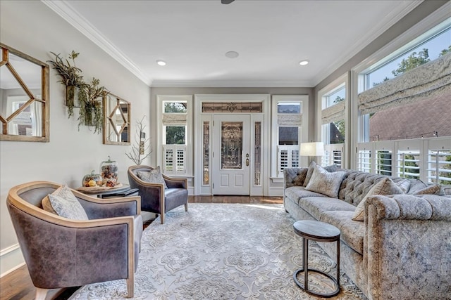 living room featuring hardwood / wood-style flooring, a wealth of natural light, and crown molding