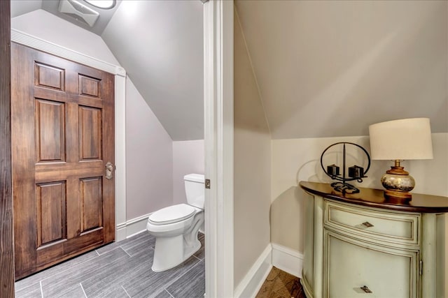 bathroom with toilet and lofted ceiling