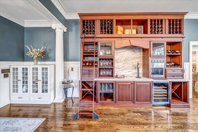 bar with dark wood-type flooring, beverage cooler, and crown molding