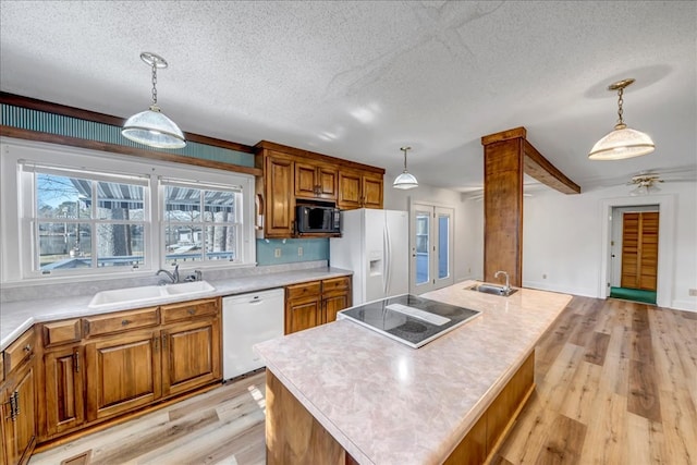 kitchen featuring sink, black appliances, a center island, and pendant lighting