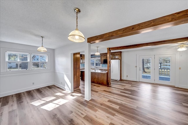 interior space with light hardwood / wood-style flooring, beam ceiling, and a textured ceiling