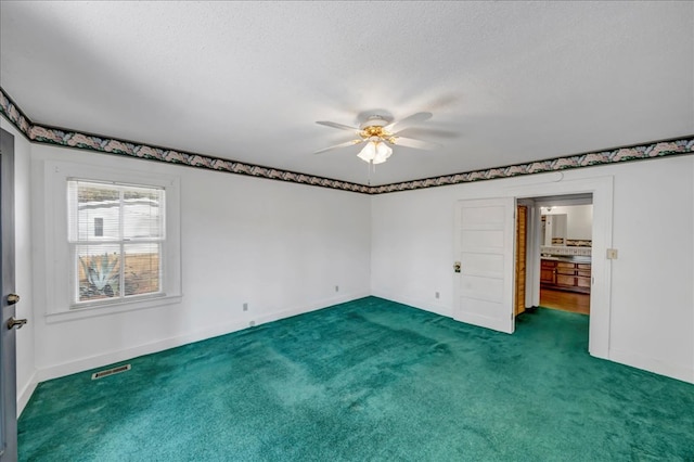 unfurnished bedroom with dark colored carpet, a textured ceiling, and ceiling fan