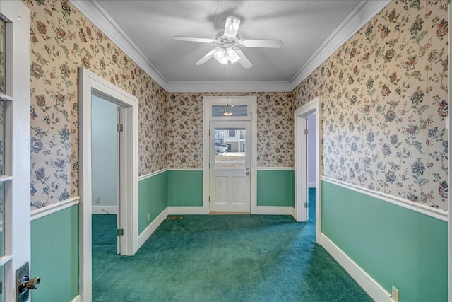 empty room with dark colored carpet, a textured ceiling, ceiling fan, and ornamental molding