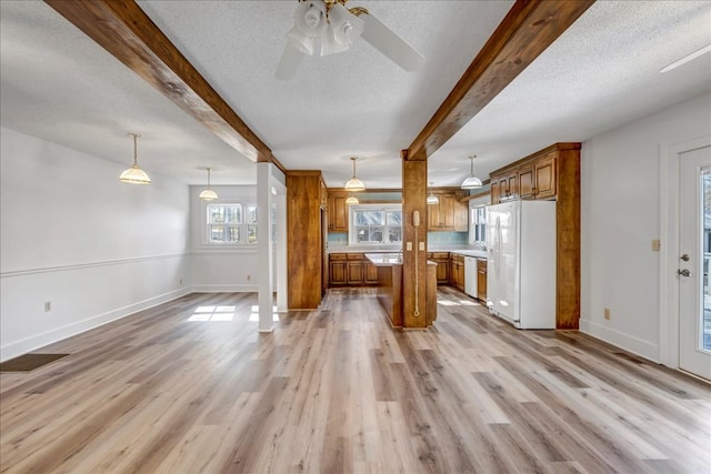 kitchen with white appliances, light wood-type flooring, and hanging light fixtures