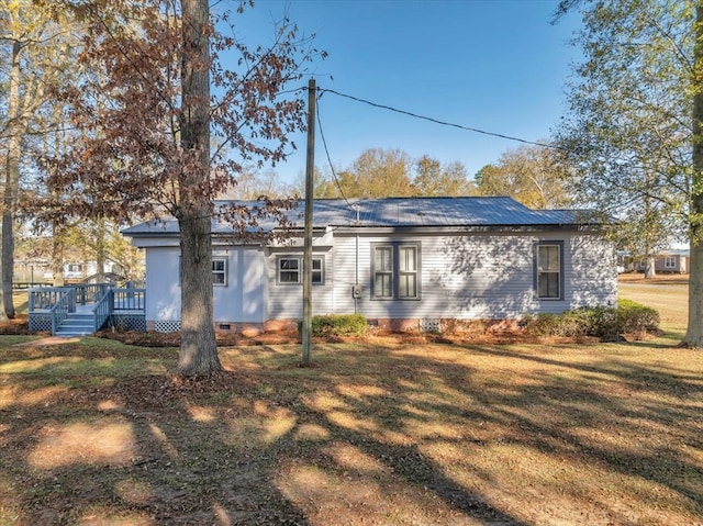 rear view of house featuring a lawn and a wooden deck