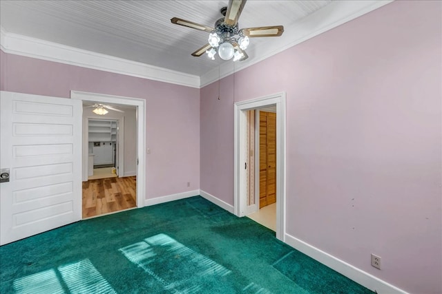 unfurnished bedroom featuring ceiling fan, dark carpet, and ornamental molding