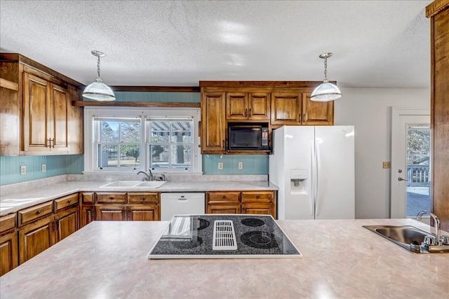 kitchen featuring black appliances, hanging light fixtures, a textured ceiling, and sink