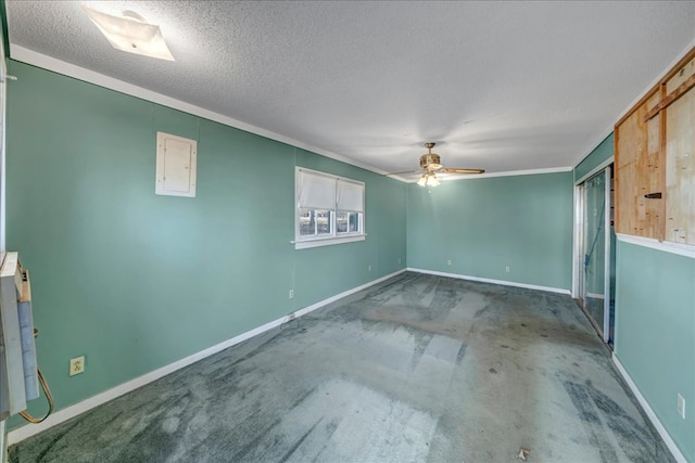 spare room featuring electric panel, a textured ceiling, ceiling fan, and ornamental molding