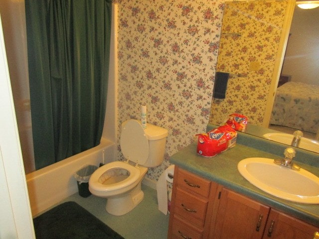 bathroom featuring toilet, shower / tub combo with curtain, vanity, and wallpapered walls