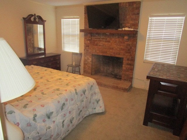 carpeted bedroom with a brick fireplace