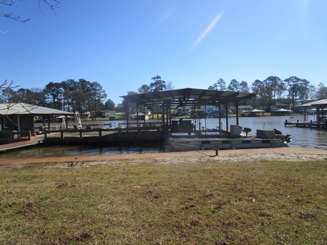 view of dock featuring a water view and a yard