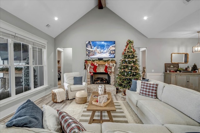 living room with a fireplace, hardwood / wood-style flooring, and vaulted ceiling with beams