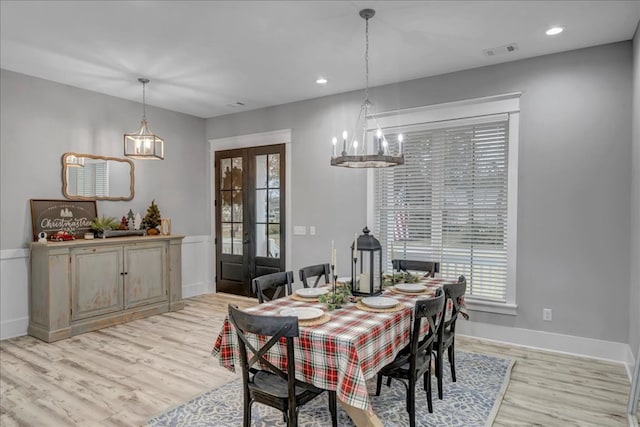 dining space with a healthy amount of sunlight, light hardwood / wood-style flooring, and french doors