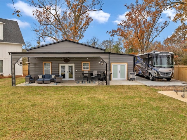 rear view of property featuring a patio area, outdoor lounge area, a yard, and french doors