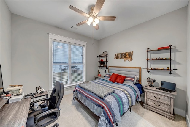 carpeted bedroom with ceiling fan and multiple windows