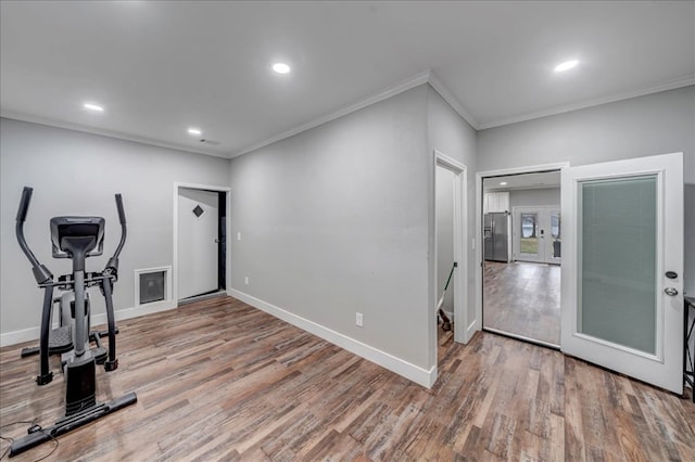 workout room featuring ornamental molding and hardwood / wood-style floors