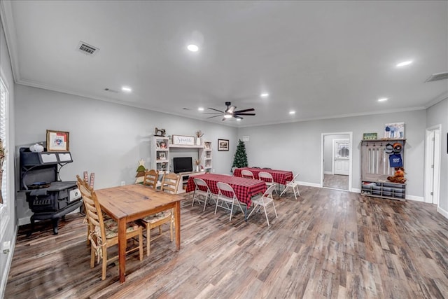 dining space with ceiling fan, crown molding, and wood-type flooring