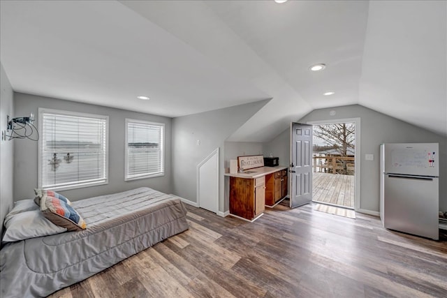 bedroom with multiple windows, dark hardwood / wood-style floors, and white refrigerator