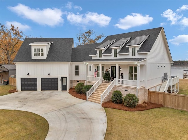 view of front of property featuring a porch, a garage, and a front lawn