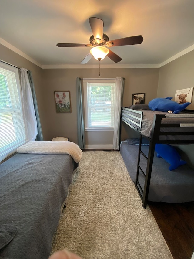 bedroom featuring ceiling fan, ornamental molding, and wood finished floors