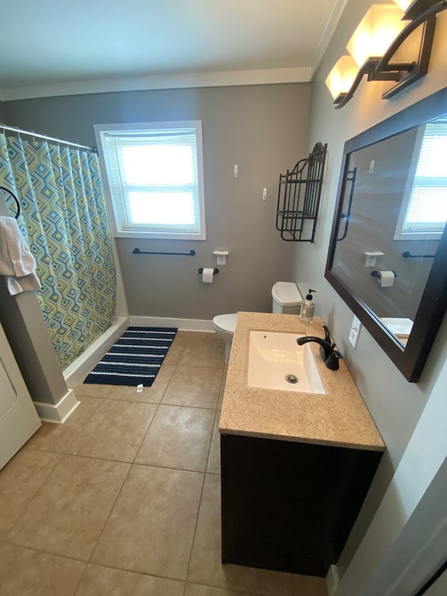 bathroom featuring toilet, tile patterned flooring, vanity, and plenty of natural light