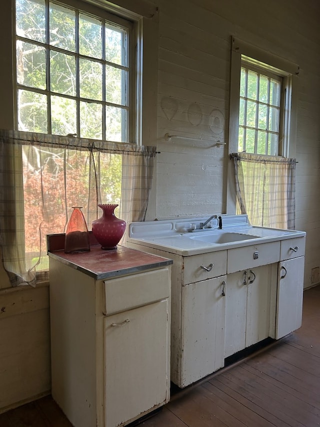 kitchen featuring sink, hardwood / wood-style floors, and white cabinets