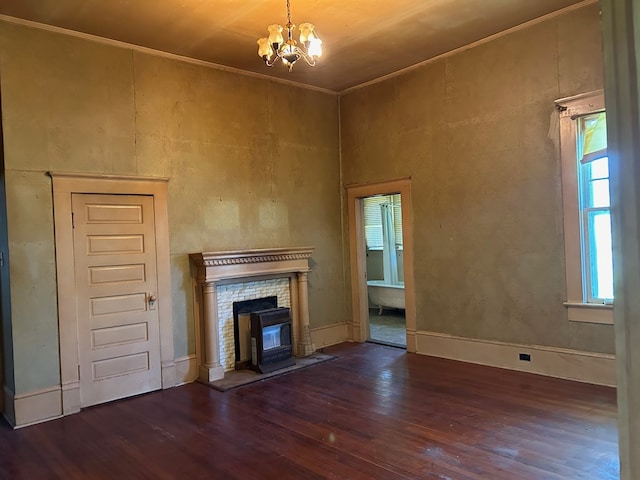 unfurnished living room with an inviting chandelier, dark hardwood / wood-style floors, and a fireplace