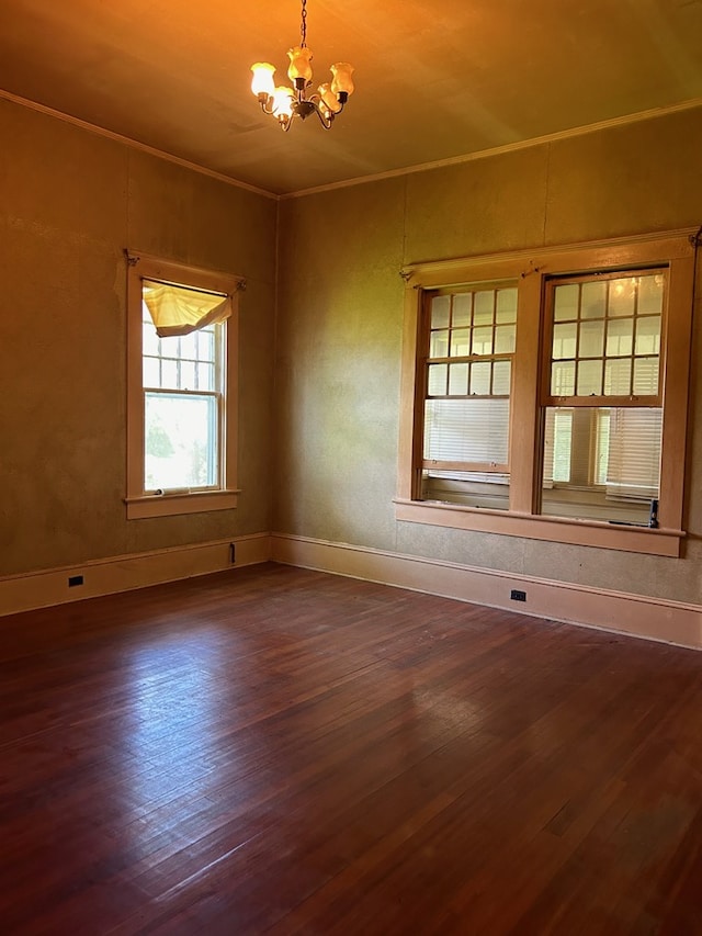 spare room featuring hardwood / wood-style floors and an inviting chandelier