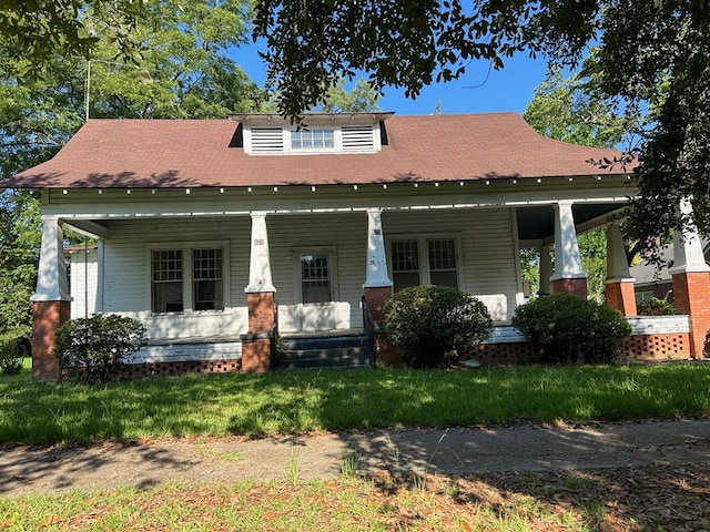 view of front facade featuring covered porch and a front lawn