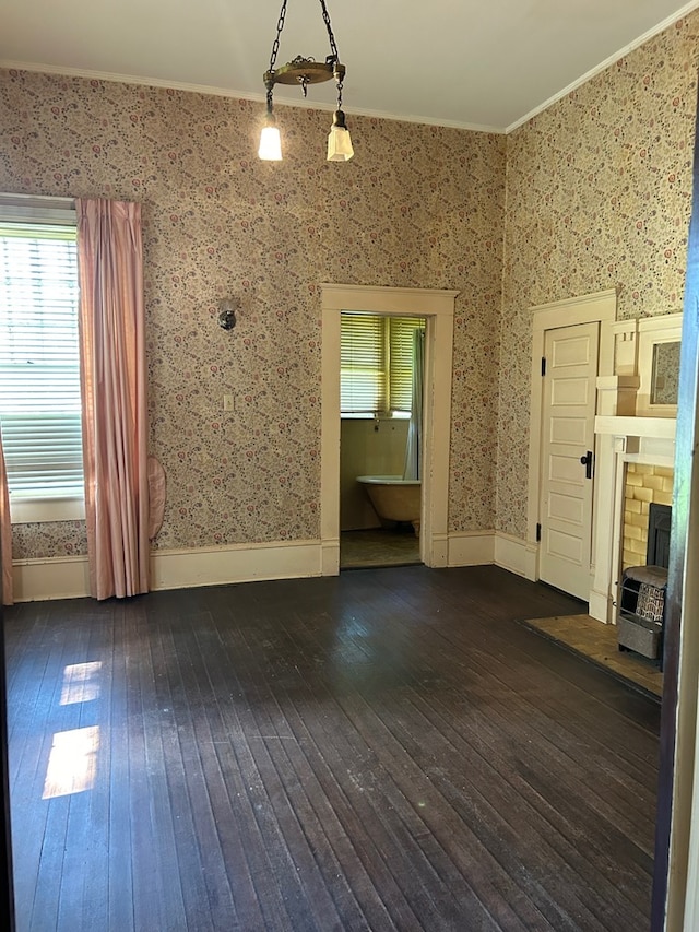 unfurnished living room with dark hardwood / wood-style floors and crown molding