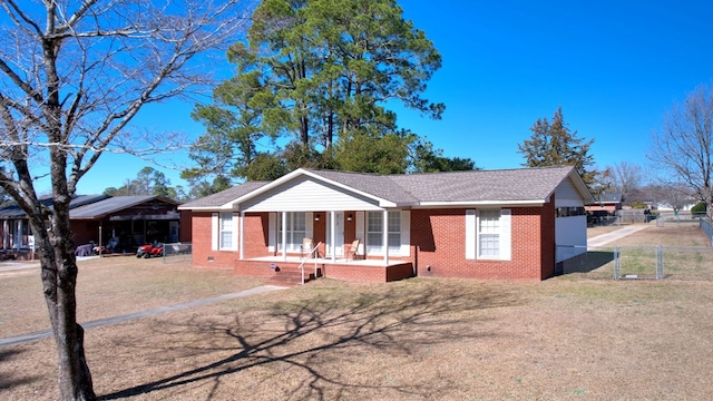 single story home with a carport, a front yard, and covered porch