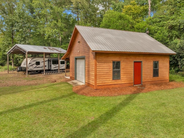 view of outbuilding featuring a garage, a lawn, and a carport