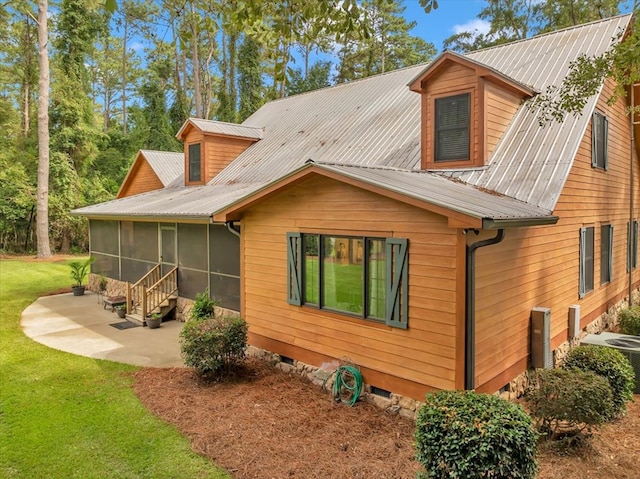 rear view of house with central air condition unit, a sunroom, a yard, and a patio