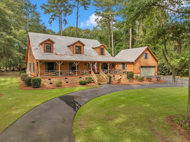 view of front of property with covered porch, a front lawn, and a garage