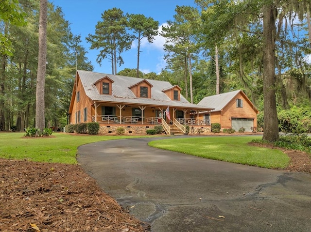 view of front of property with a front yard, a porch, and a garage