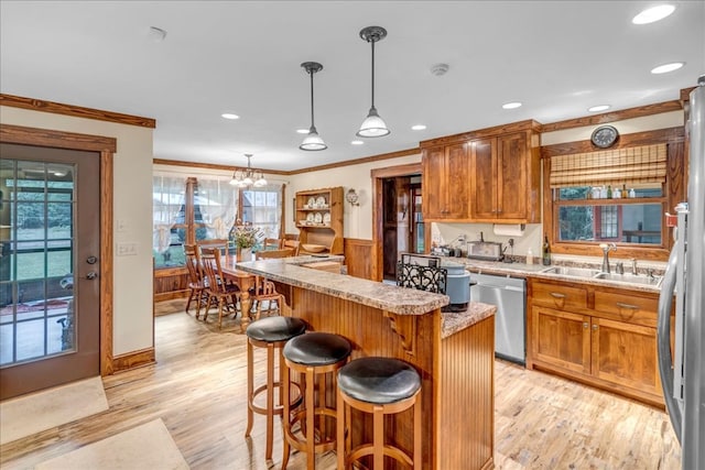 kitchen featuring crown molding, pendant lighting, sink, a center island, and stainless steel appliances