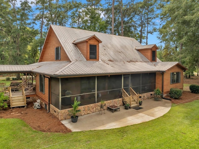 rear view of property featuring a patio, a yard, and a sunroom