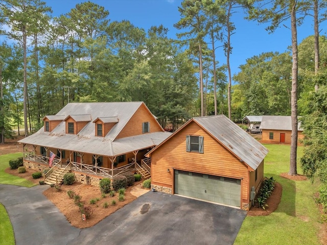 view of front of property with a garage, covered porch, and a front yard