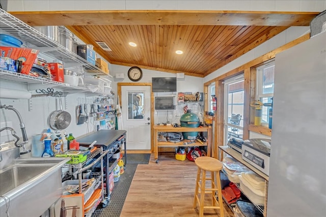 kitchen featuring lofted ceiling, wooden ceiling, recessed lighting, wood finished floors, and a sink